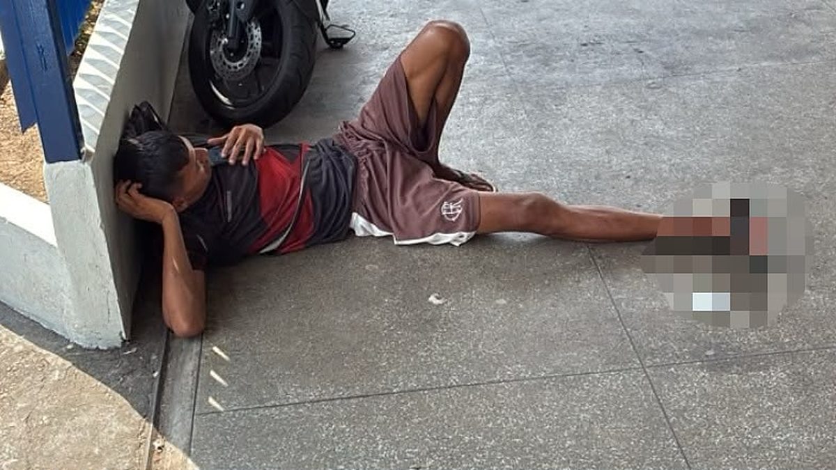Homem ferido deitado na calçada em frente a unidade de saúde na Compensa, em Manaus