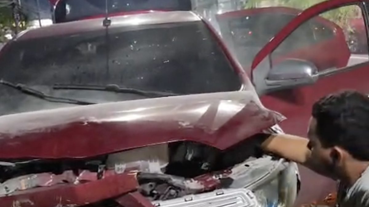 Carro vermelho com a frente destruída após bater na mureta da passagem de nível da Compensa